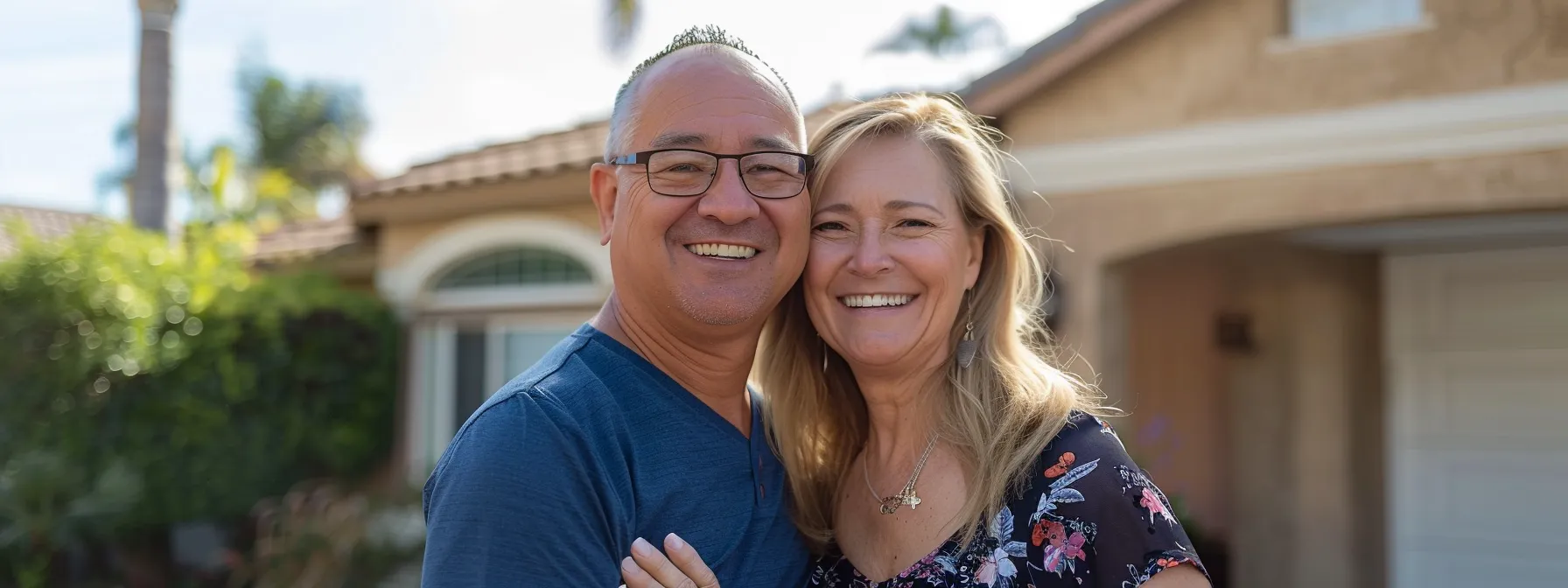 a happy couple smiling in front of their newly refinanced home in sunny san diego.