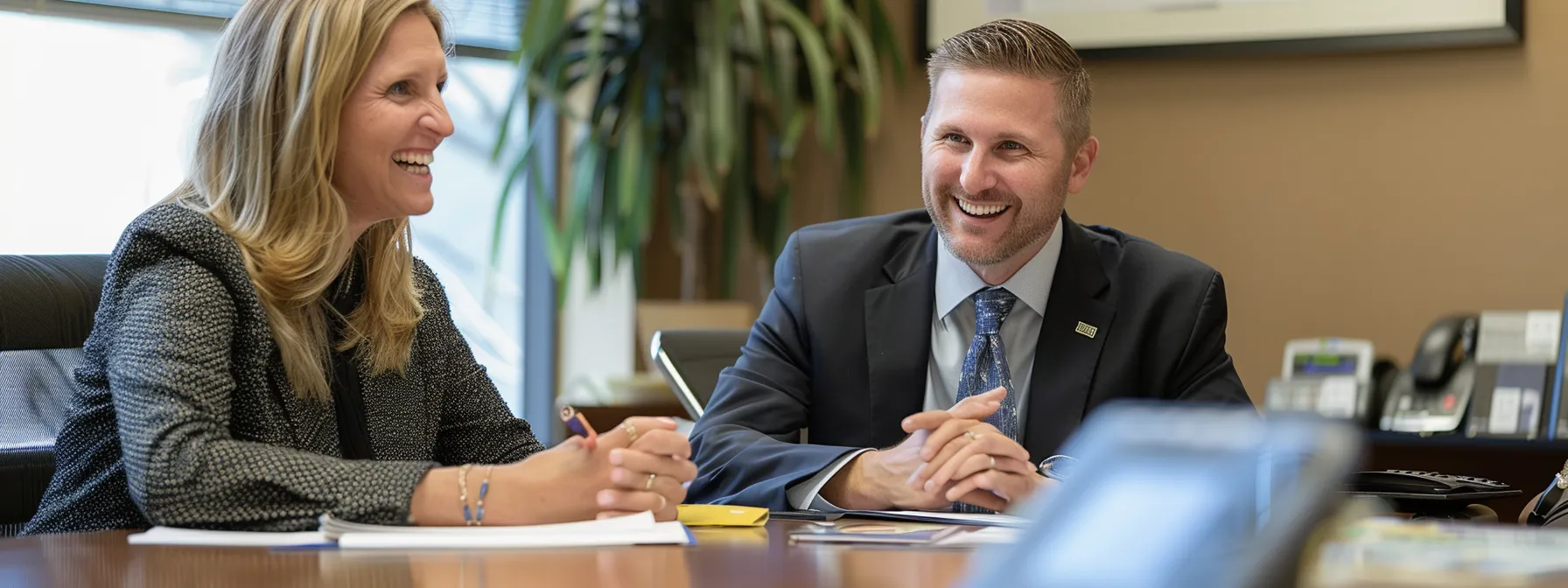 a smiling couple sitting at a table with a team of san diego mortgage experts, reviewing loan options and discussing financial goals.