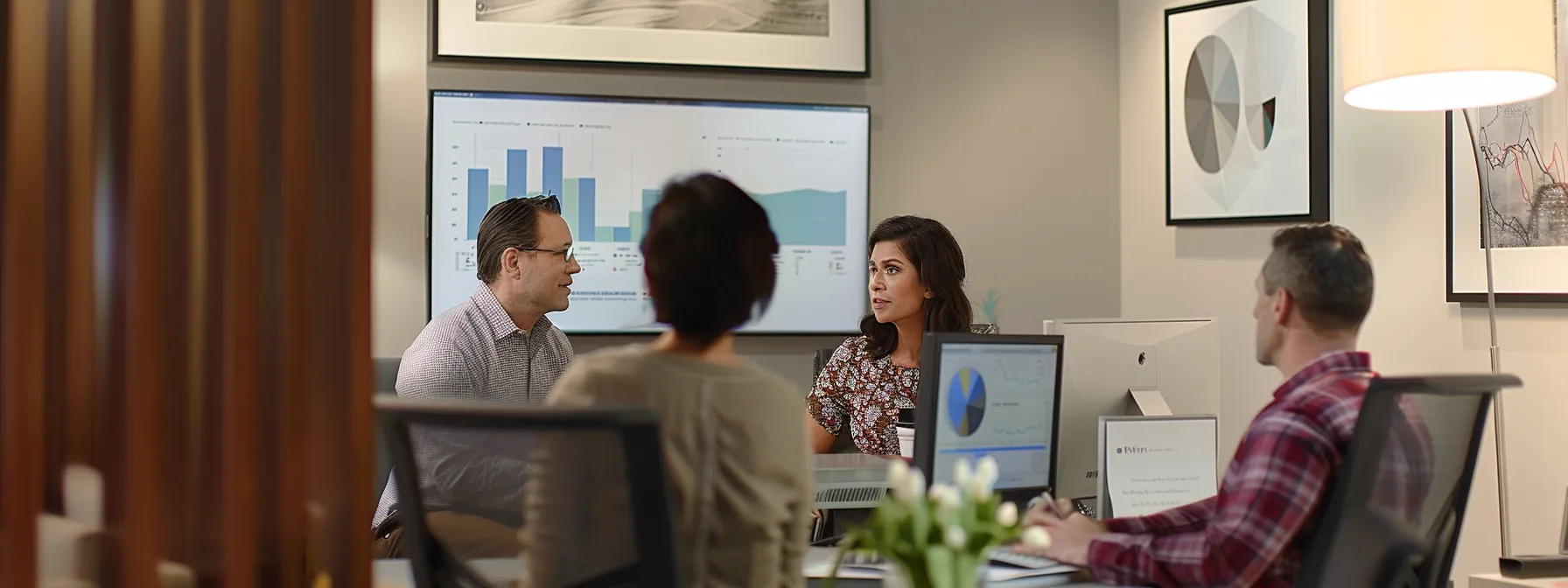 a couple consulting with a financial advisor in a modern office, looking at charts and graphs on a computer screen, while discussing mortgage refinance options. a couple consulting with a financial advisor in a modern office, looking at charts and graphs on a computer screen, while discussing mortgage refinance options.