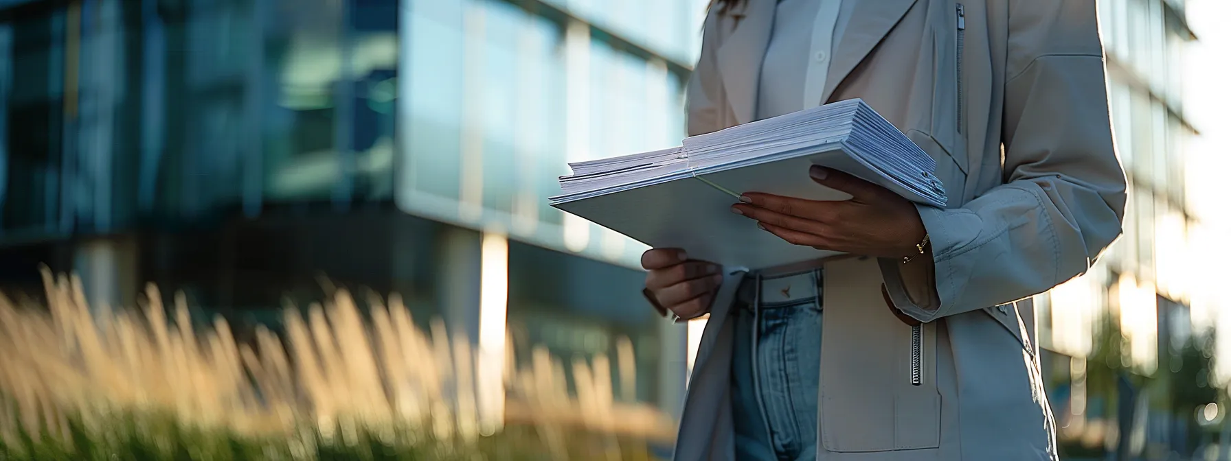 a person confidently holding a stack of important documents, standing in front of a sleek modern office building, ready to secure a va home loan in san diego.