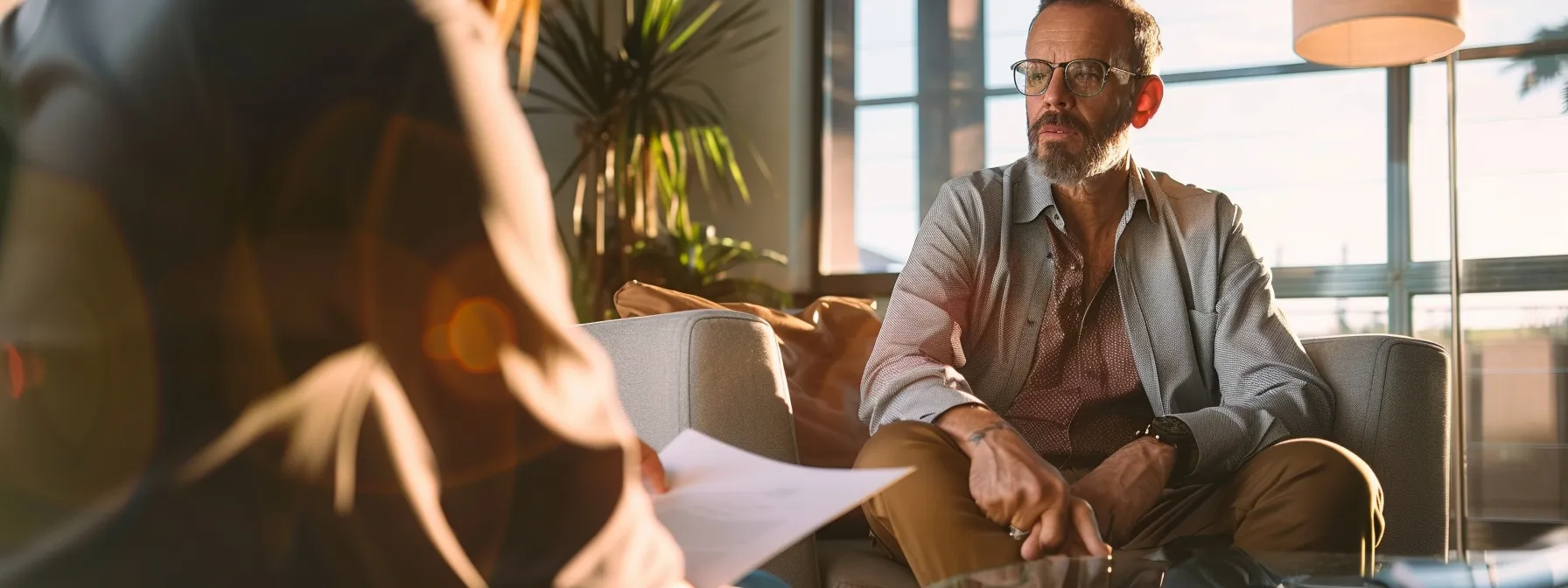 a person sitting with a mortgage broker, discussing closing costs and fees for refinancing their san diego home.